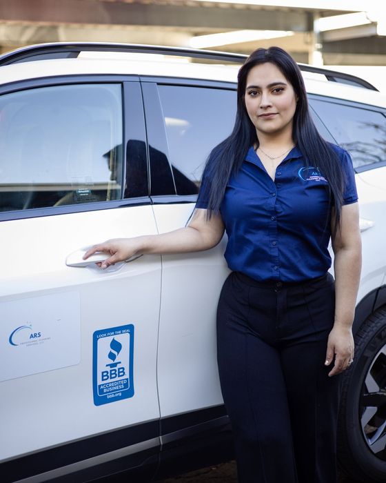 Damaris Solis, owner of ARS Professional Cleaning Services, next to the company vehicle